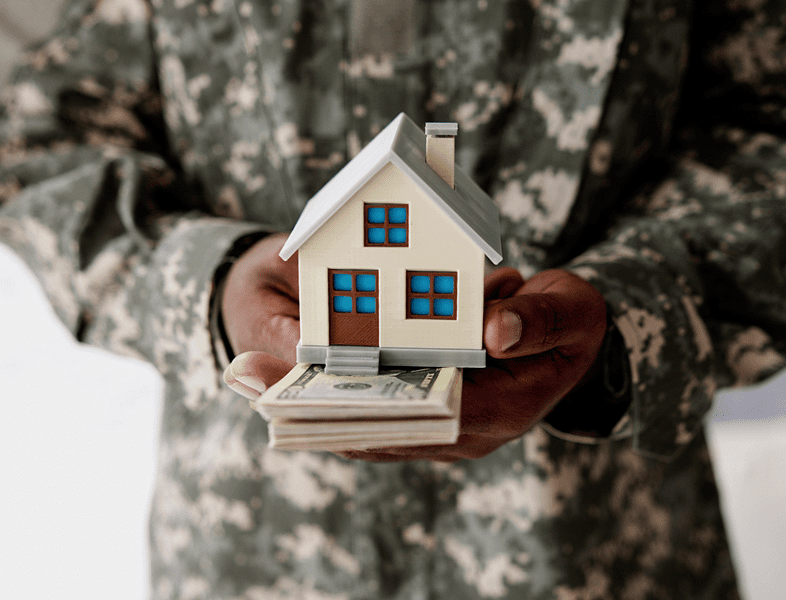 Soldier holding house model and cash